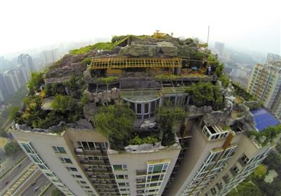 　　昨日，身穿橘黃色馬甲的工作人員在人濟山莊樓頂拆除違章建筑。新京報記者 吳江 攝