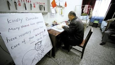 張大爺在門衛(wèi)室里工作，旁邊是紅爆網(wǎng)絡(luò)的溫馨提示牌記者