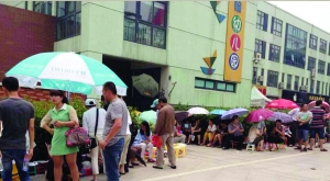 金壇市實(shí)驗(yàn)幼兒園門前，家長(zhǎng)在排隊(duì)