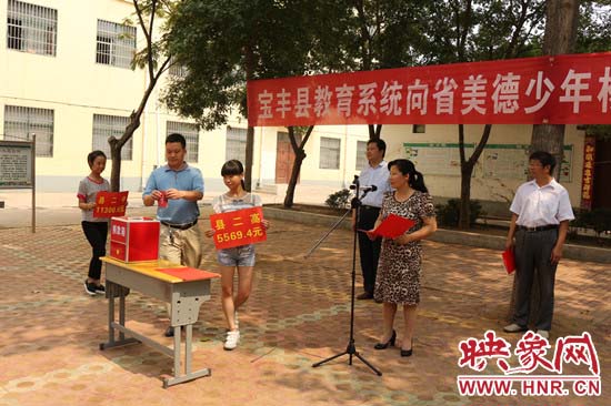 寶豐縣教育系統(tǒng)全體人員在石橋鎮(zhèn)中學為“美德少年”楊冠明同學捐款。