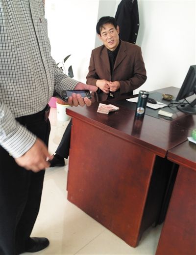 10月29日，獻縣國稅局稽查局辦公室內(nèi)，一名企業(yè)主交了兩萬元現(xiàn)金在桌上。新京報記者 孟祥超 攝
