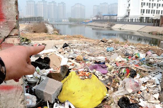 金水河長江路橋下河水發(fā)臭，水邊堆放眾多垃圾