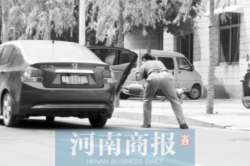 鄭州西區(qū)一氧氣廠門前，有人充氣后，將氧氣瓶裝上私家車運走
