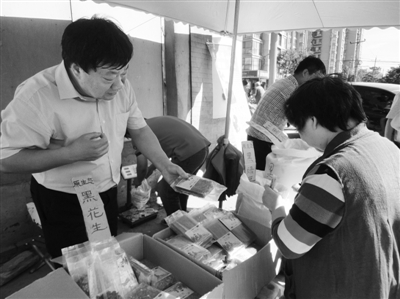 昨日，河南企業(yè)家劉春喜在京“練攤”，為顧客挑選綠豆。新京報記者 張玉學(xué) 攝