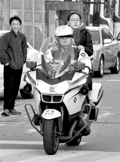7日，首爾，警察將一名考生送抵考場。新華社發(fā)