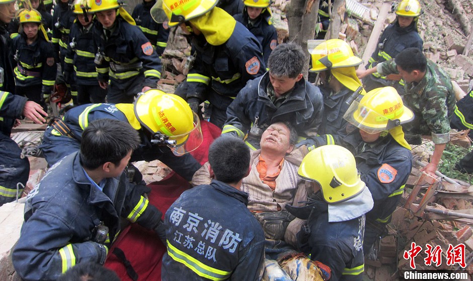 圖為南京消防隊員從廢墟中將傷者抬出。中新社發(fā) 梅亮 攝