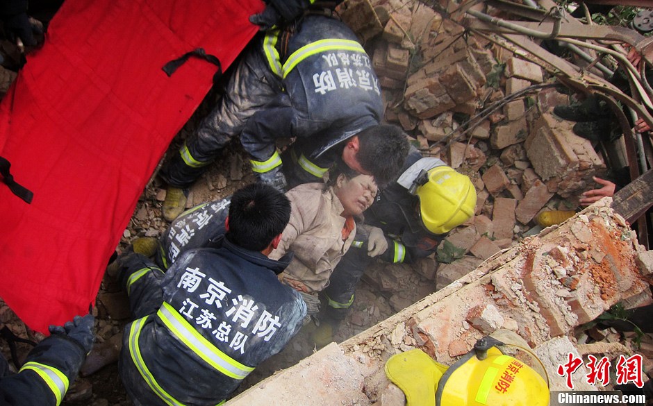 圖為南京消防隊員從廢墟中將傷者抬出。中新社發(fā) 梅亮 攝
