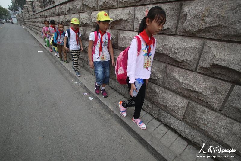 2013年09月11日，濟南運署街上，小學生走史上“最窄人行道”上學。圖片來源：CFP
