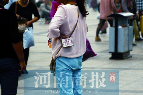火車站廣場(chǎng)，一女子拿著寫有不同房型價(jià)位的卡片在拉客，不少市民抱怨，受過此類“騷擾”