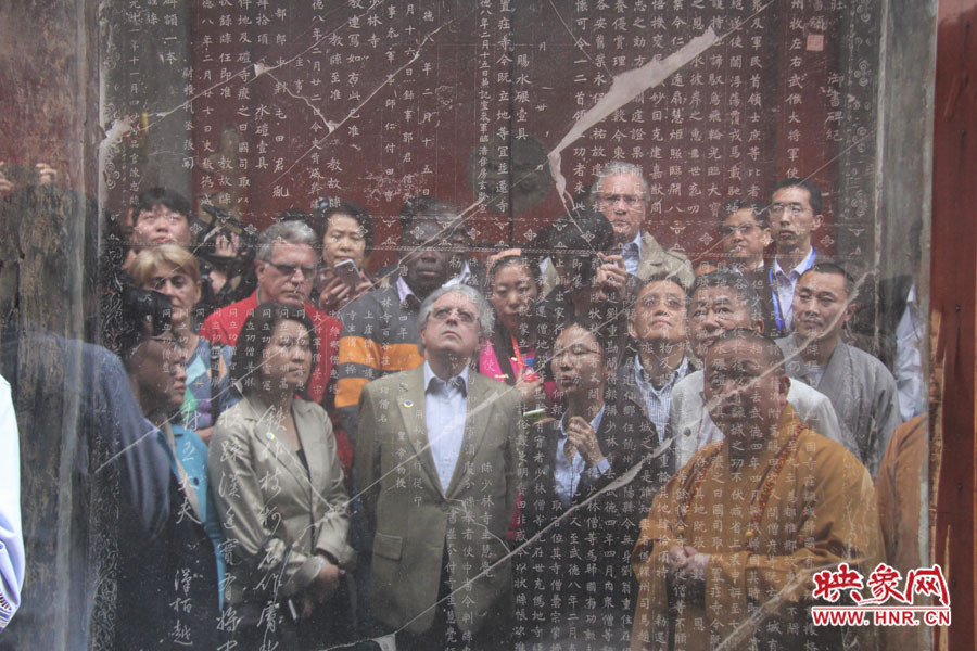 在一塊石碑前，少林寺方丈正在講解
