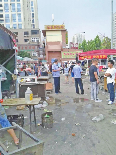 昨天，執(zhí)法人員在京廣路長(zhǎng)江路口整治“僵尸圍擋”及圍擋內(nèi)的攤販。