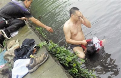 網(wǎng)友貼出民警張光聰一出河水就睜不開(kāi)眼，用手抹去臉上臟水的照片。