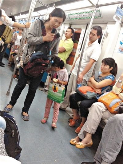 6月27日，舒馨帶一女孩在地鐵十號線行乞。她因被疑帶多個不同小孩乞討被警方搜尋。新京報記者 申志民 攝