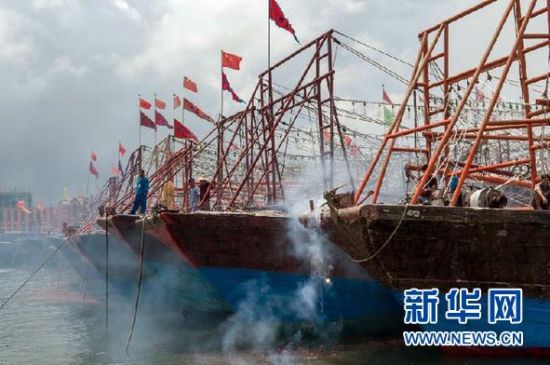 2013年8月1日 南海開漁日 臨高迎新港 8月1日，海南省臨高縣漁民在船上鳴放鞭炮慶祝武蓮港開港。