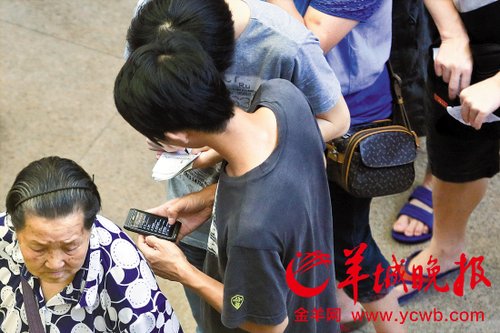排隊的“黃?！备魇謭?zhí)一疊白紙，上面寫好了要掛號的人的信息，包括姓名、電話、要掛的科室等。穿黑白花紋衣服的老婆婆正在排隊掛號