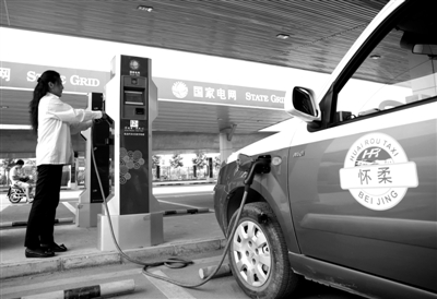 9月11日，懷柔區(qū)，電動(dòng)出租車司機(jī)正在為車輛充電。