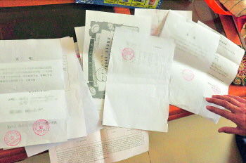 60歲的市民仇先生為了辦理公證所需的這些證明材料,半個月時間里跑了30多趟腿。記者　李萌博　攝