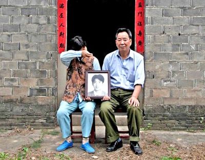江蘇鎮(zhèn)江，老劉夫婦捧著獨(dú)生子的遺像在老家前留影南方都市報(bào)供圖L