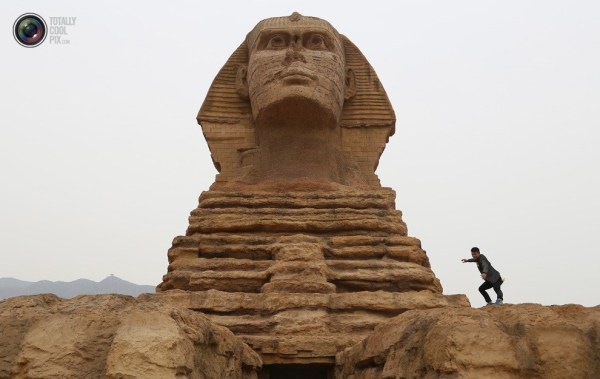 石家莊郊外，一名男子與山寨版獅身人面像合影留念。