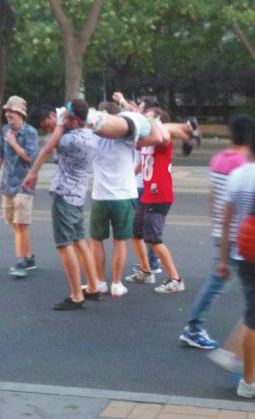 　四名外籍男子一同扛起醉漢拍照。