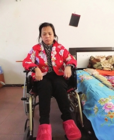 陳慶霞坐在輪椅上。她現(xiàn)在下身癱瘓，疾病纏身，生活不能自理。