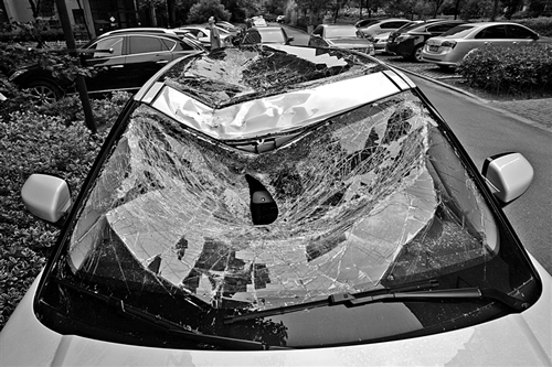 越野車車蓋以及前擋風(fēng)玻璃被砸得凹陷進(jìn)去。見(jiàn)習(xí)記者姚卡/攝