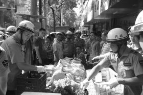 7月11日，瀏陽市北正中路，執(zhí)法人員暫扣張海的水果。這是瀏陽市城管局拍攝的執(zhí)法現(xiàn)場圖。