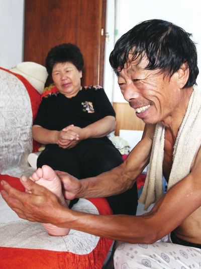 慈成富為老伴按摩。