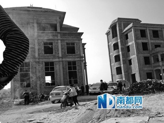 兩棟被舉報的違建樓下昨日一度聚集了超過百人，城管離開后逐漸散去。南都記者張志韜實習生宋超攝