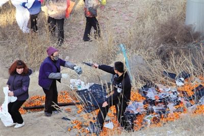1月4日，連霍高速蘭州市榆中縣和平鎮(zhèn)段，一名警察舉著槍驅(qū)散哄搶橘子的村民。圖/CFP