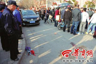 車禍現(xiàn)場的血跡被人用土覆蓋，旁邊則放著紅領(lǐng)巾、一雙童鞋和一頂帽子 本報(bào)記者 趙彬 攝