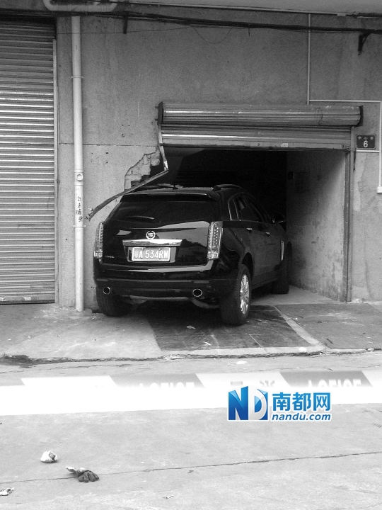 　昨日，凱迪拉克撞人后停在一倉(cāng)庫(kù)門(mén)口，車(chē)后有一攤血跡。 南都記者陳杰生攝