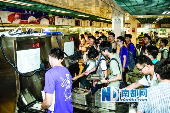 昨日，華南理工大學(xué)一食堂內(nèi)，學(xué)生們正在使用新安裝的自動(dòng)打飯機(jī)打飯。中新社發(fā)