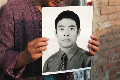 5月19日，朝陽(yáng)北路，母親捧著張東文的遺像。新京報(bào)記者 侯少卿 攝