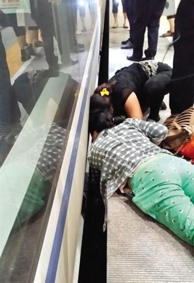 一女子趴在站臺(tái)上，救跌入列車和站臺(tái)間隙的男童。網(wǎng)友璀璨的星月夜 攝