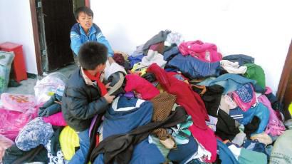 學(xué)生在幫忙整理收到的捐贈(zèng)衣服。得石中心校供圖