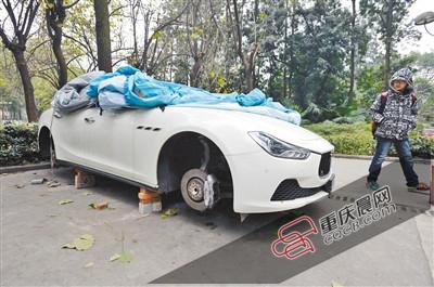 昨日，停放在重慶大學(xué)B區(qū)的一輛瑪莎拉蒂豪車被架在幾塊磚頭上，車輪不翼而飛。 重慶晨報記者 胡杰 攝