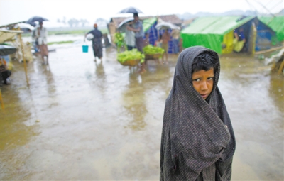 5月14日，緬甸若開邦實(shí)兌難民營，羅興亞族難民在雨中行走。熱帶風(fēng)暴“馬哈森”即將登陸緬甸，這里的難民開始乘船撤離。