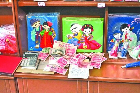 　　2012年6月21日，在朝鮮羅先特別市的一家商店里，柜臺上散落著一些人民幣。在朝鮮，人民幣比本國