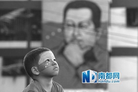 3月5日，一名委內(nèi)瑞拉兒童仰望天空，他身后是查韋斯的陵墓。