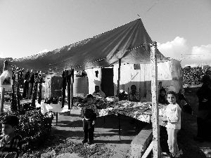 黎巴嫩一敘利亞難民營(yíng)，難民支起攤鋪賣衣服掙錢。