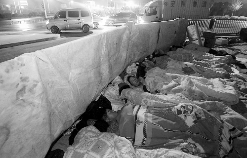 在寒冷的冬夜，為了能省點錢，方便接活，民工們?nèi)运跇蛳隆? complete=