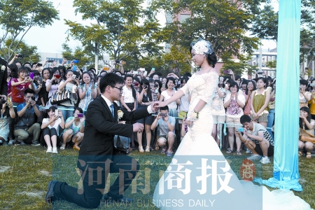 在學(xué)校操場的草坪上，兩名畢業(yè)生舉行婚禮，有同學(xué)感動地抹起眼淚