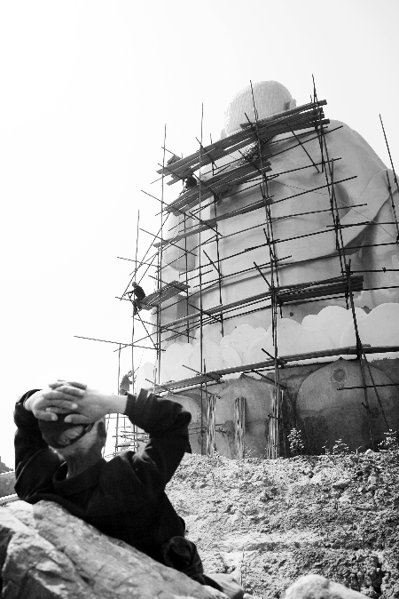 今年4月26日，工作人員將帆布蓋在“佛像”頭像上