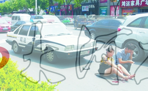 事故發(fā)生后，警車司機（右）下車查看傷者并撥打120，倆“領導”穩(wěn)坐車內引發(fā)圍觀者不滿。