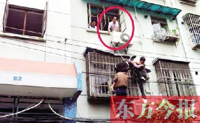 施救現(xiàn)場(chǎng)，劉鵬（圈內(nèi)）先用繩子捆住老太確保安全 勞動(dòng)報(bào)記者 郭娜 供圖