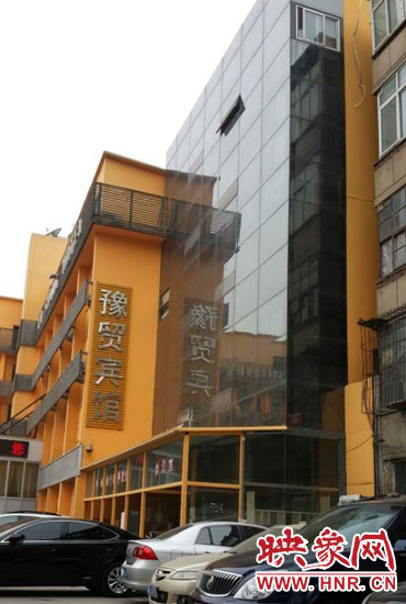 該酒店為加蓋樓層統(tǒng)一安裝上黑色玻璃，從前面看不出加蓋的痕跡