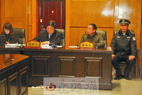 庭審現(xiàn)場，被告人坐在律師身旁為自己辯護。