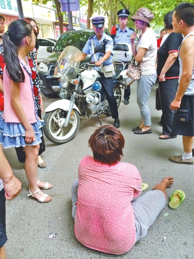 在鄭州優(yōu)勝南路東三街交叉口向東100米處，一名短發(fā)中年女子平躺在路南快車道上，身旁還有一只掉落的拖鞋