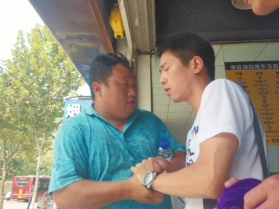 記者正查看照片，突遭藍(lán)衣男強(qiáng)搶手機(jī)。